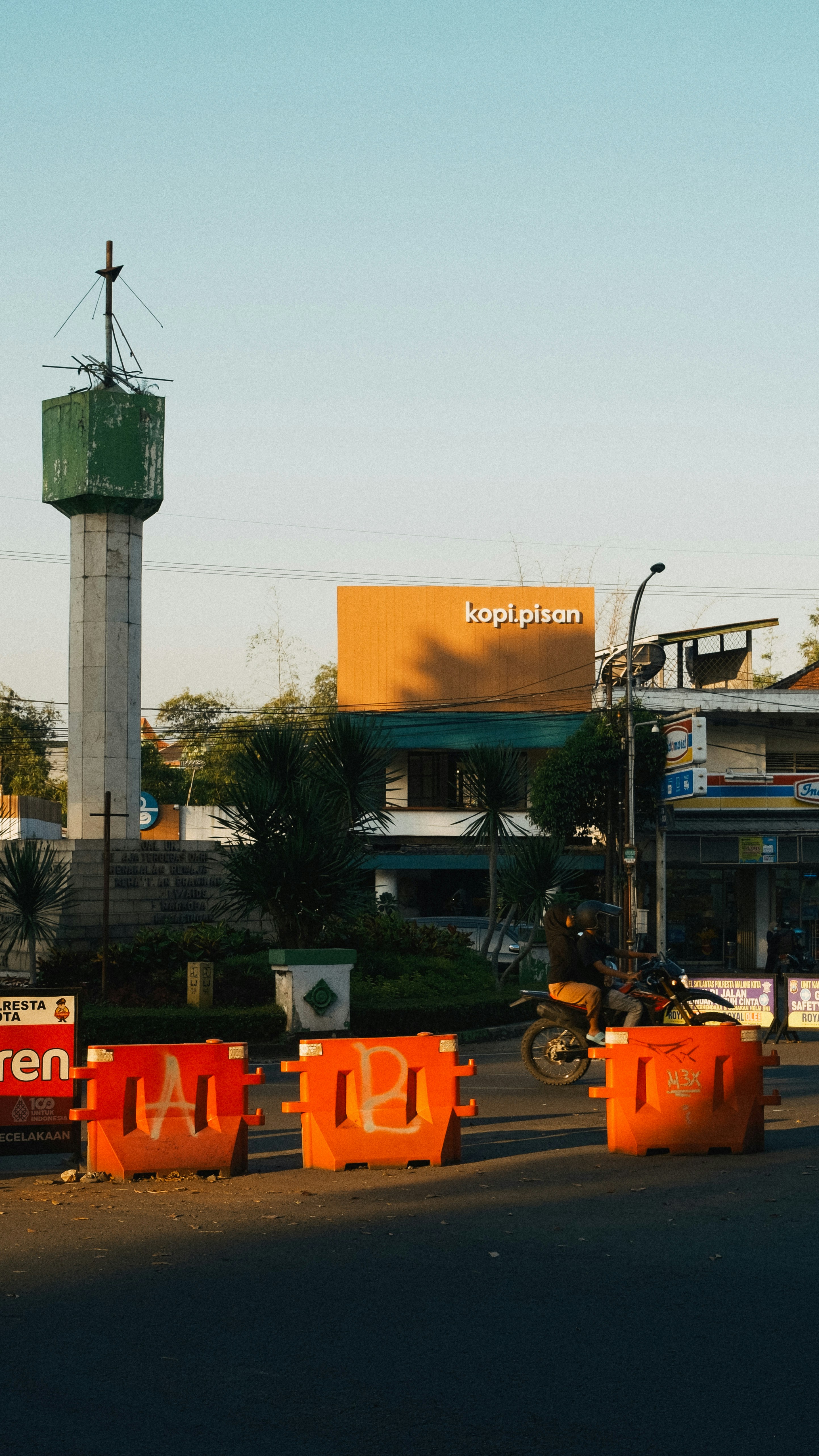 a street with traffic cones and a tower in the background