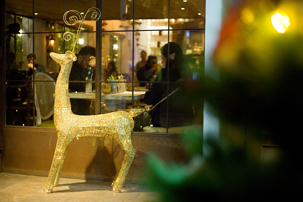 a golden deer statue in front of a restaurant