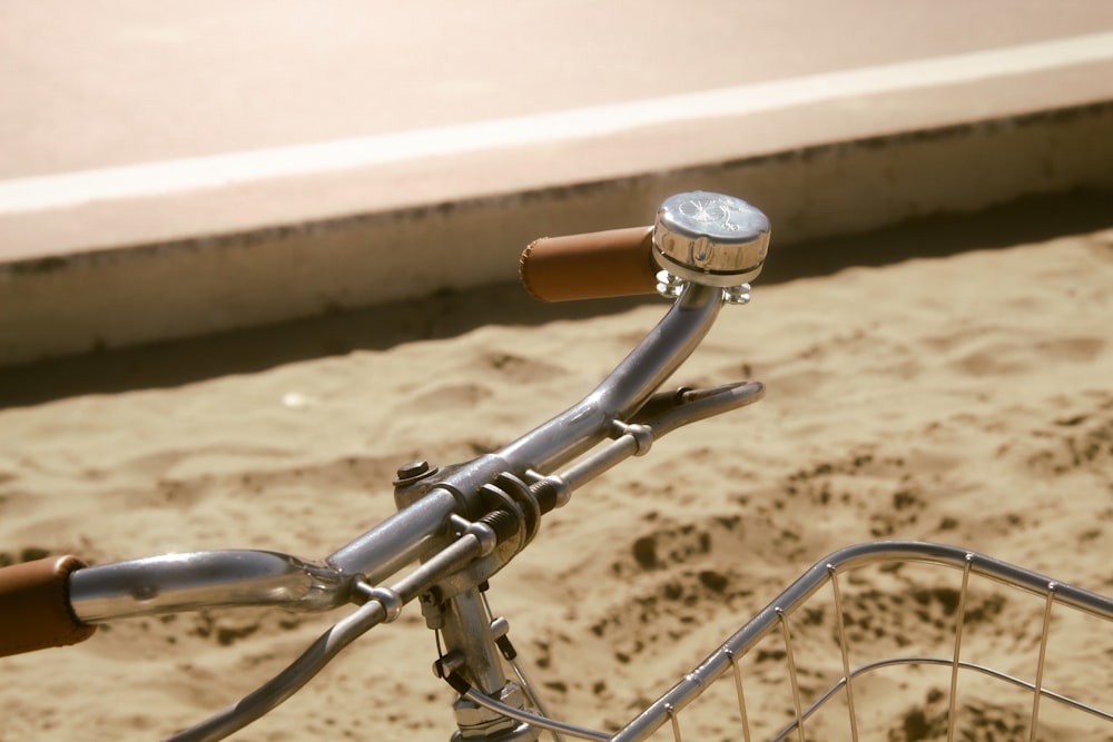 a close up of a bike handlebar on a beach