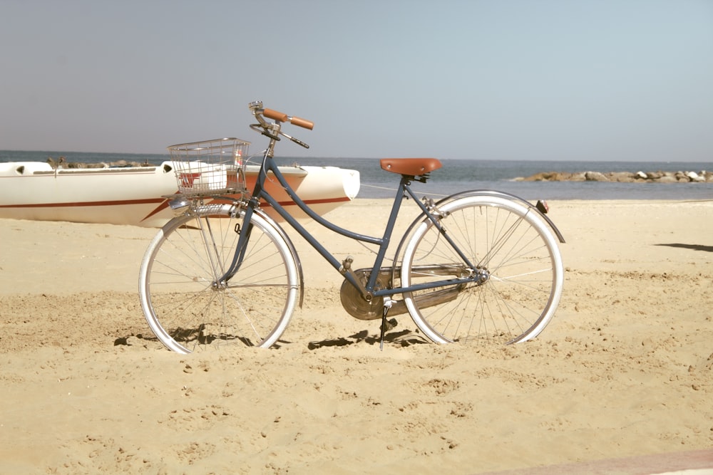 a bike parked on a beach next to a boat