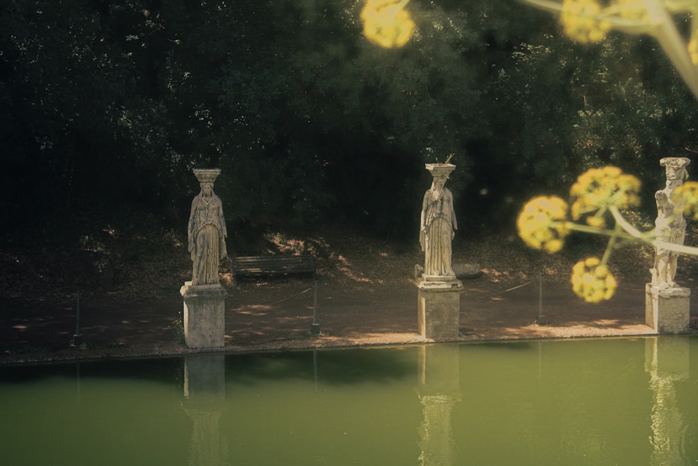 a group of statues sitting next to a body of water