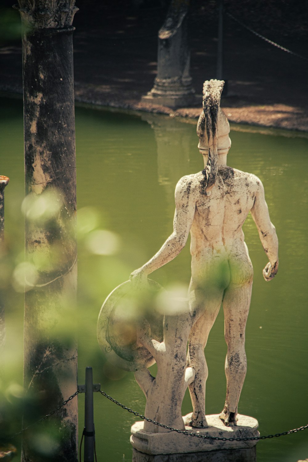 a statue of a man standing next to a body of water