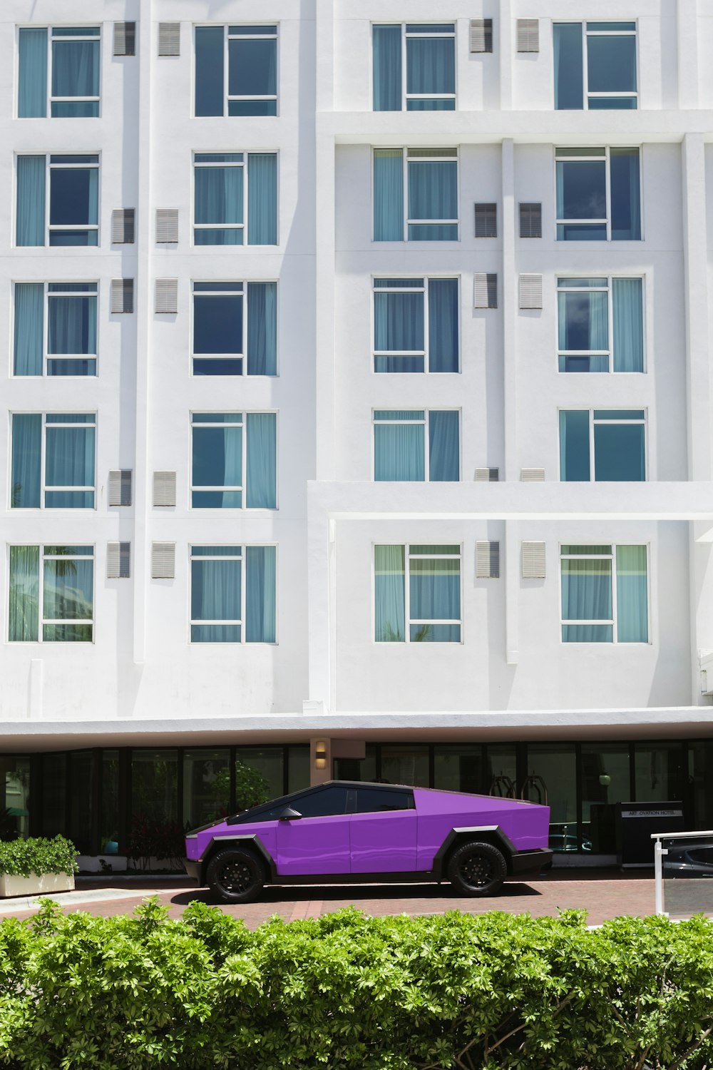 a purple car parked in front of a white building