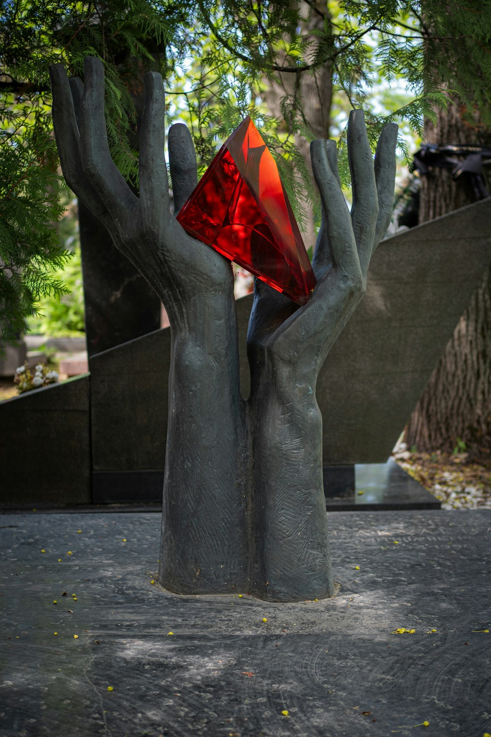 a sculpture of two hands holding a red triangle