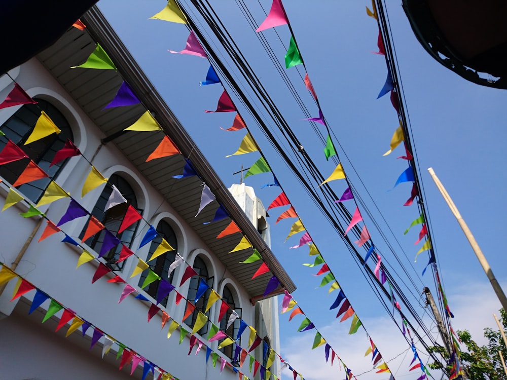 a building with many colorful flags hanging from it's sides