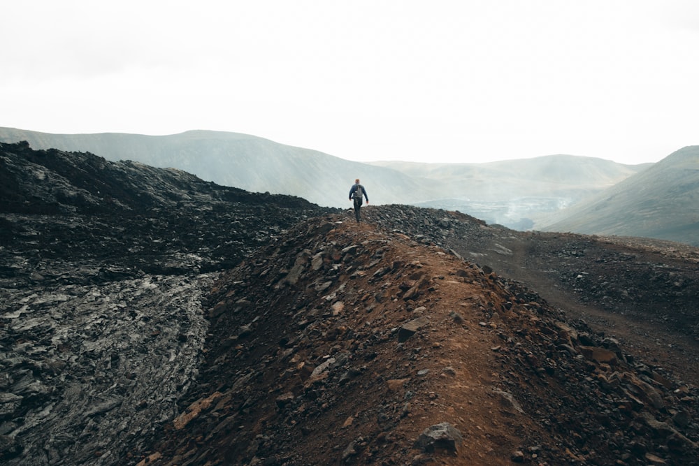 uma pessoa em pé no topo de uma colina de terra