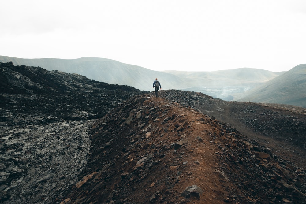 a person standing on top of a dirt hill