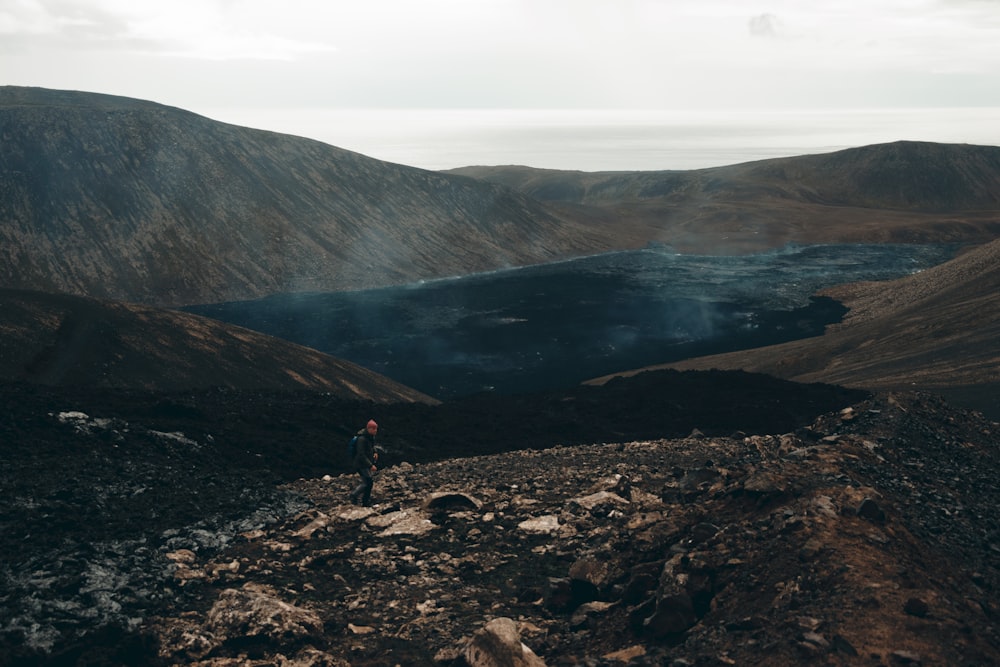 a man standing on top of a rocky hillside