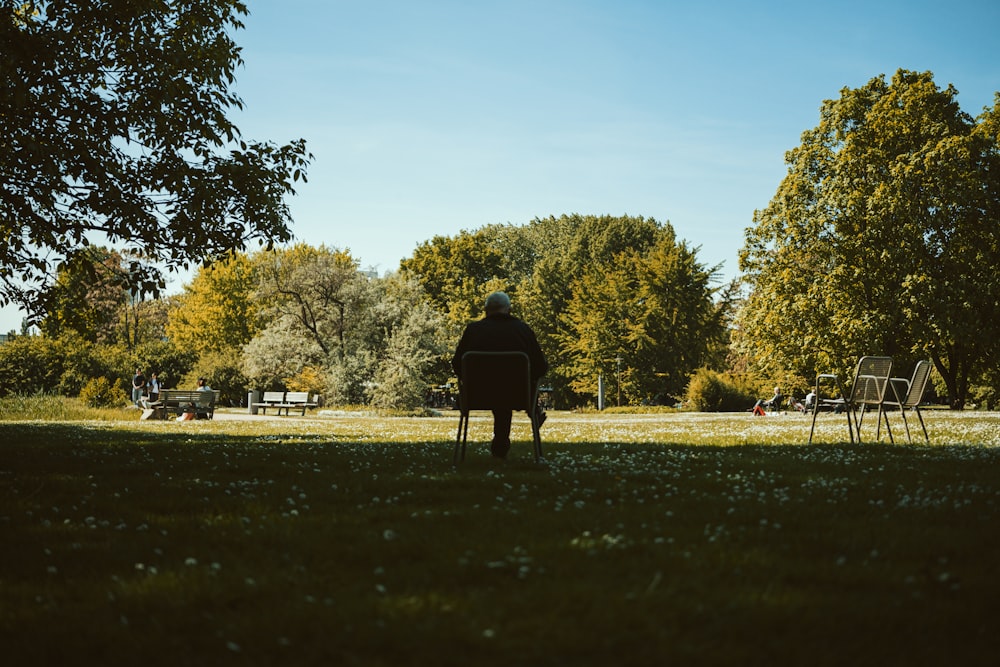 a person sitting on a bench in a park