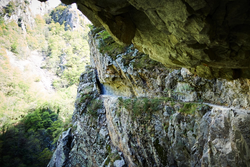 a man is climbing up a cliff with a rope