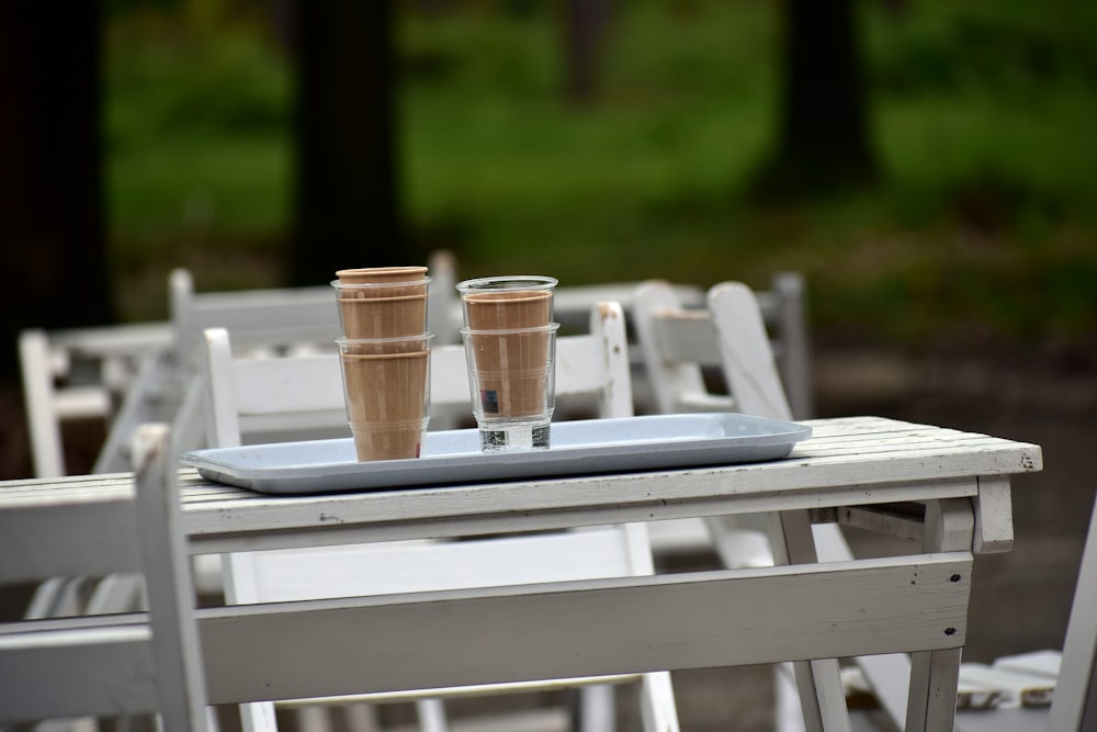 two cups of coffee sit on a tray on a table