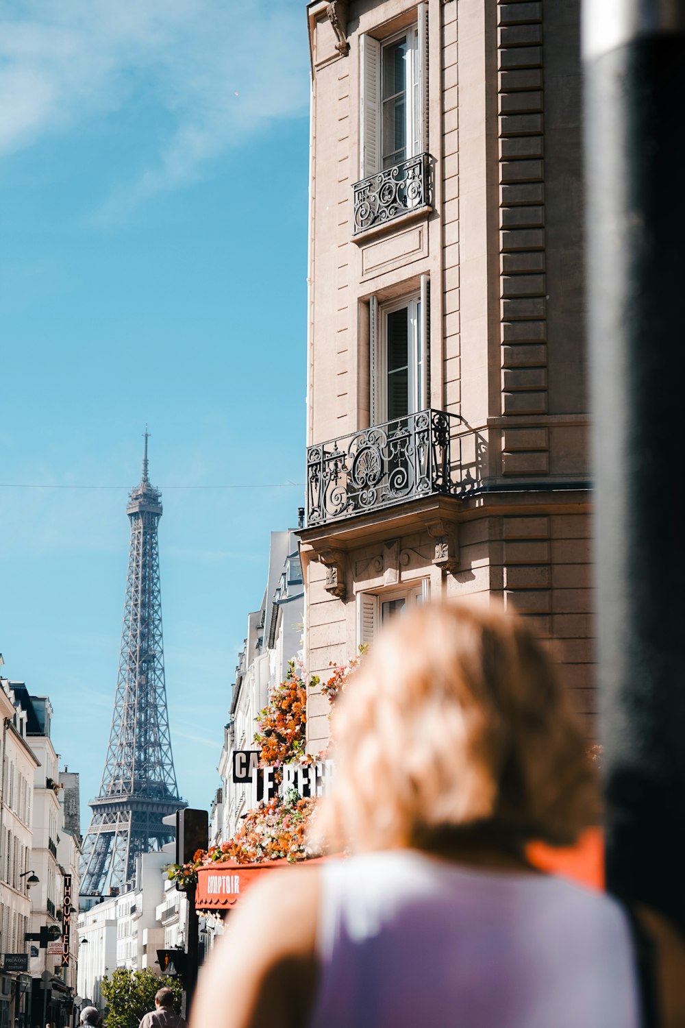 a woman walking down a street next to a tall building