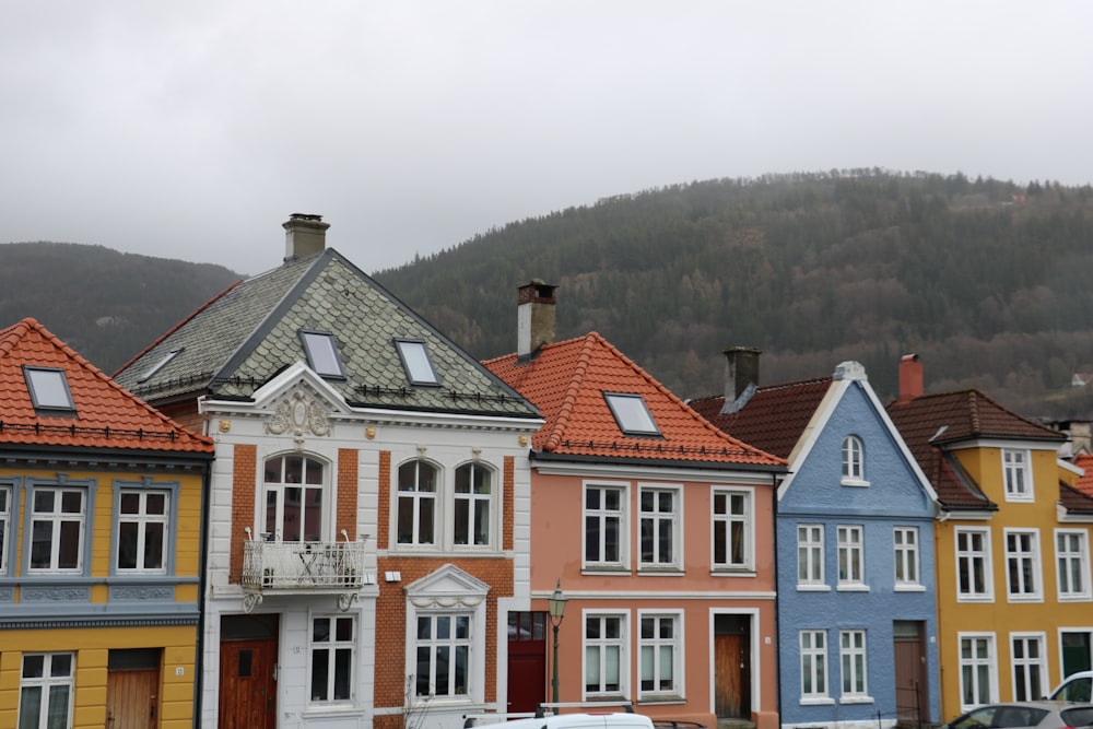 a row of colorful houses with a mountain in the background