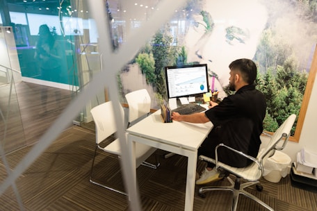 a man sitting at a desk working on a computer