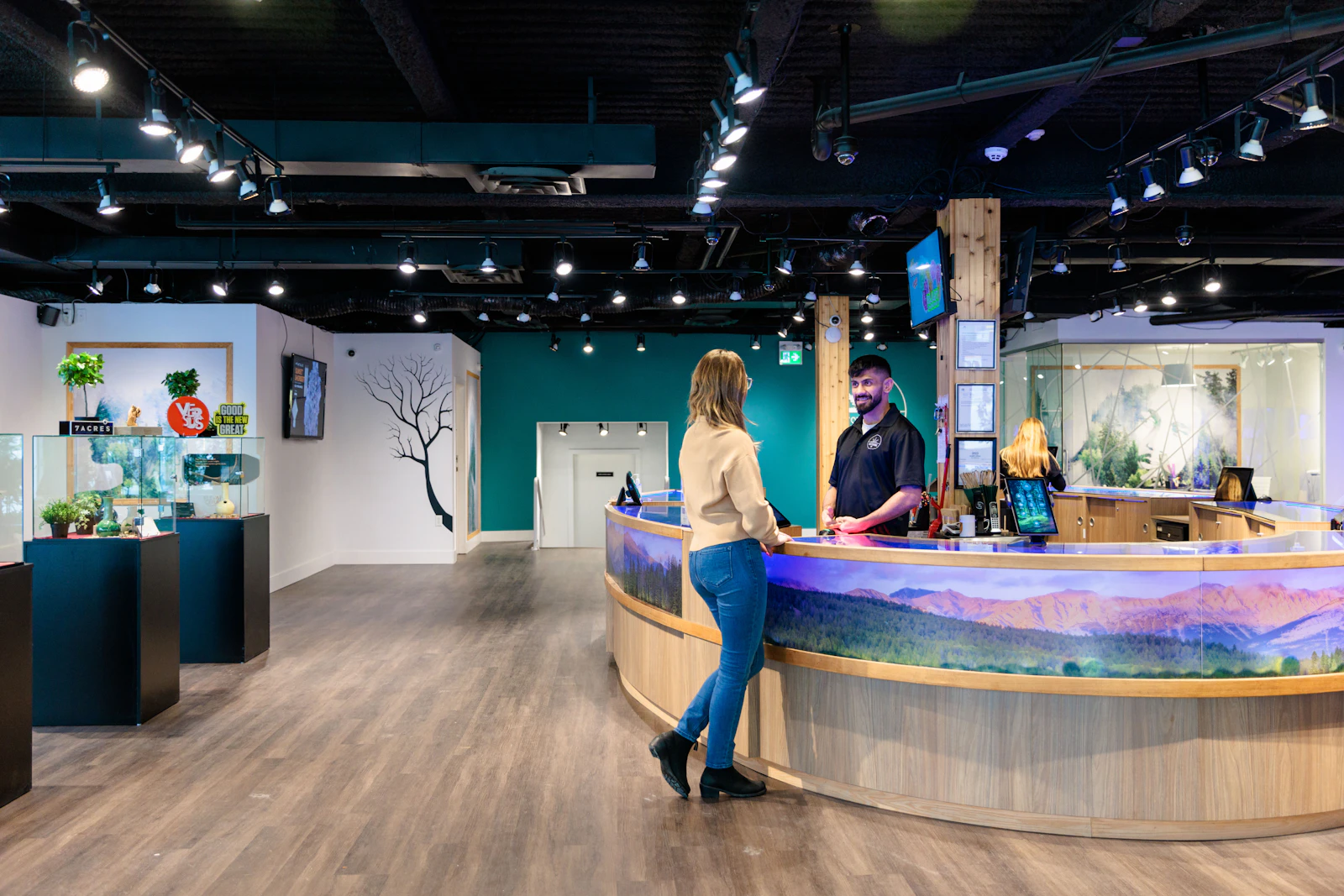 Budtenders assisting customers at a dispensary checkout counter running cannabis point of sale software