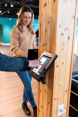 a woman standing next to a man holding a tablet