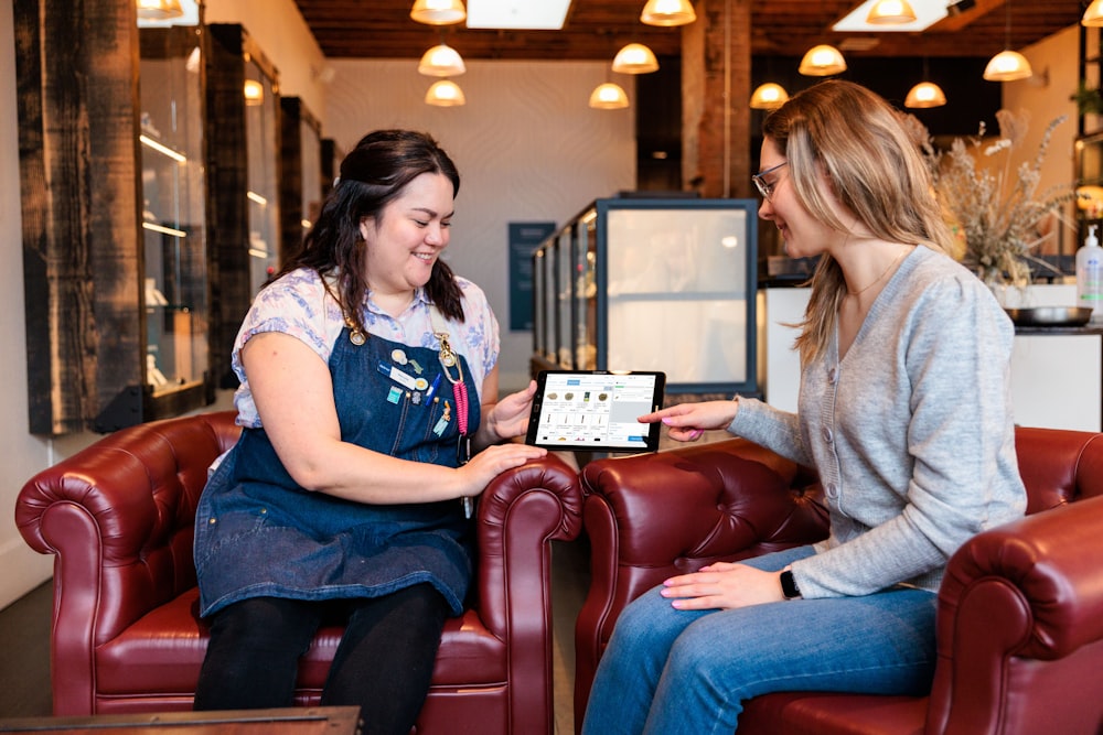 two women sitting in chairs talking to each other