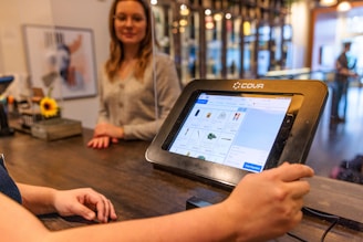 a person sitting at a table with a tablet