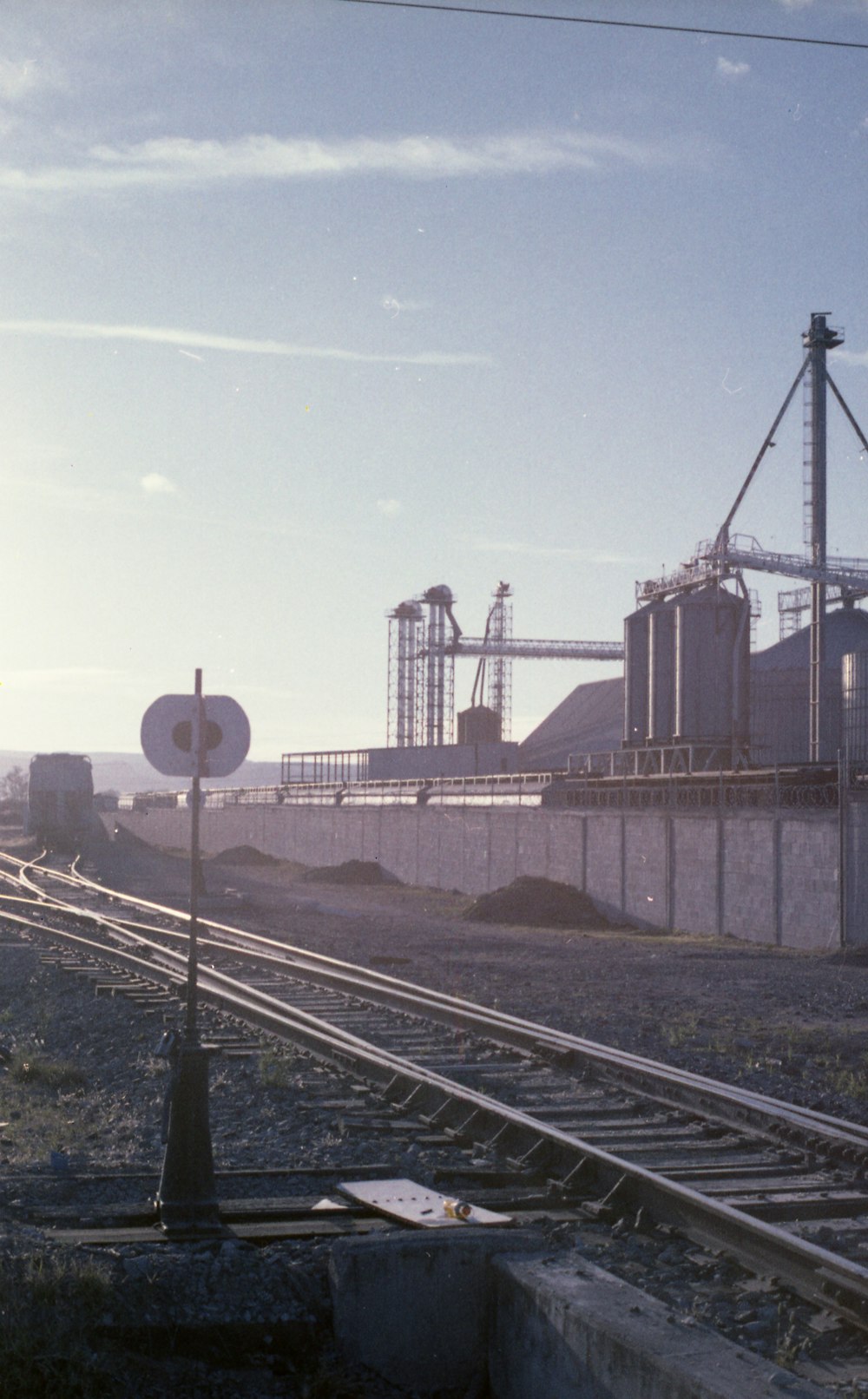 a train traveling past a factory on a train track