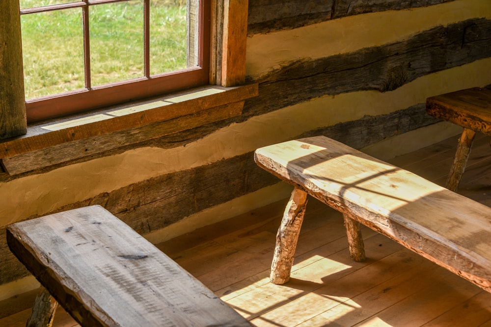 a wooden bench sitting in front of a window