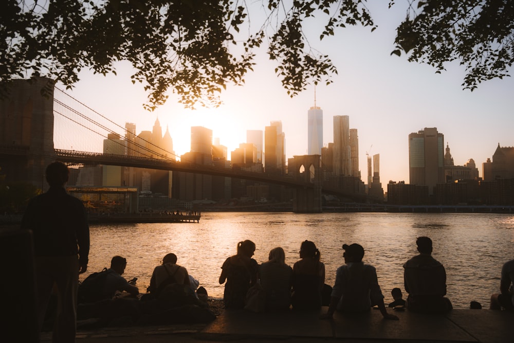 a group of people sitting next to each other near a body of water