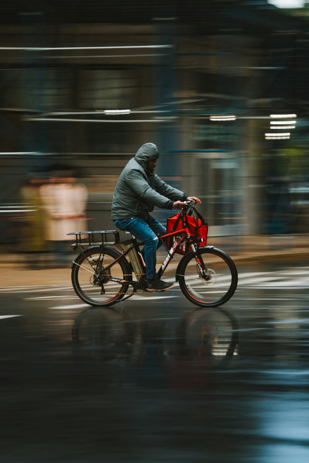 a man riding a bike down a rain soaked street