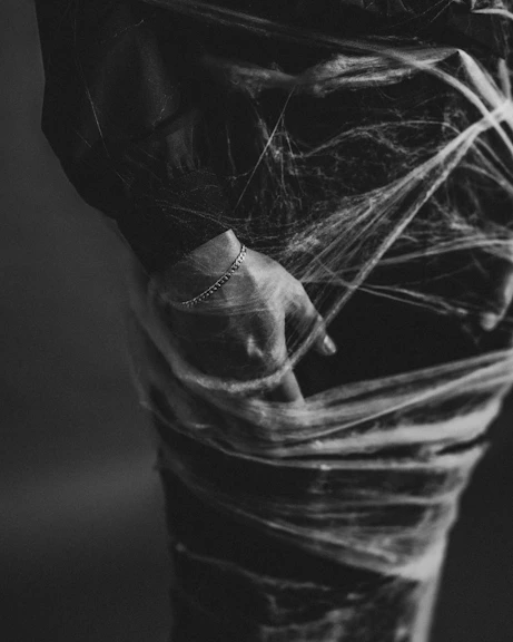 a black and white photo of a person wrapped in plastic