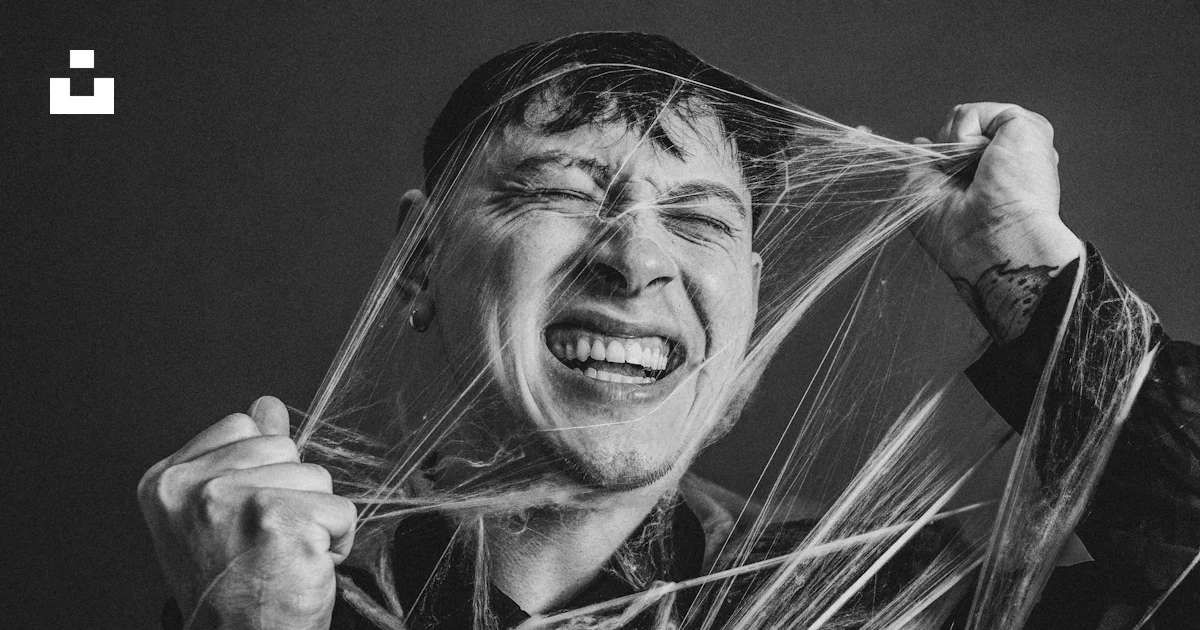 A man holding a string wrapped around his face photo – Free Grey Image ...