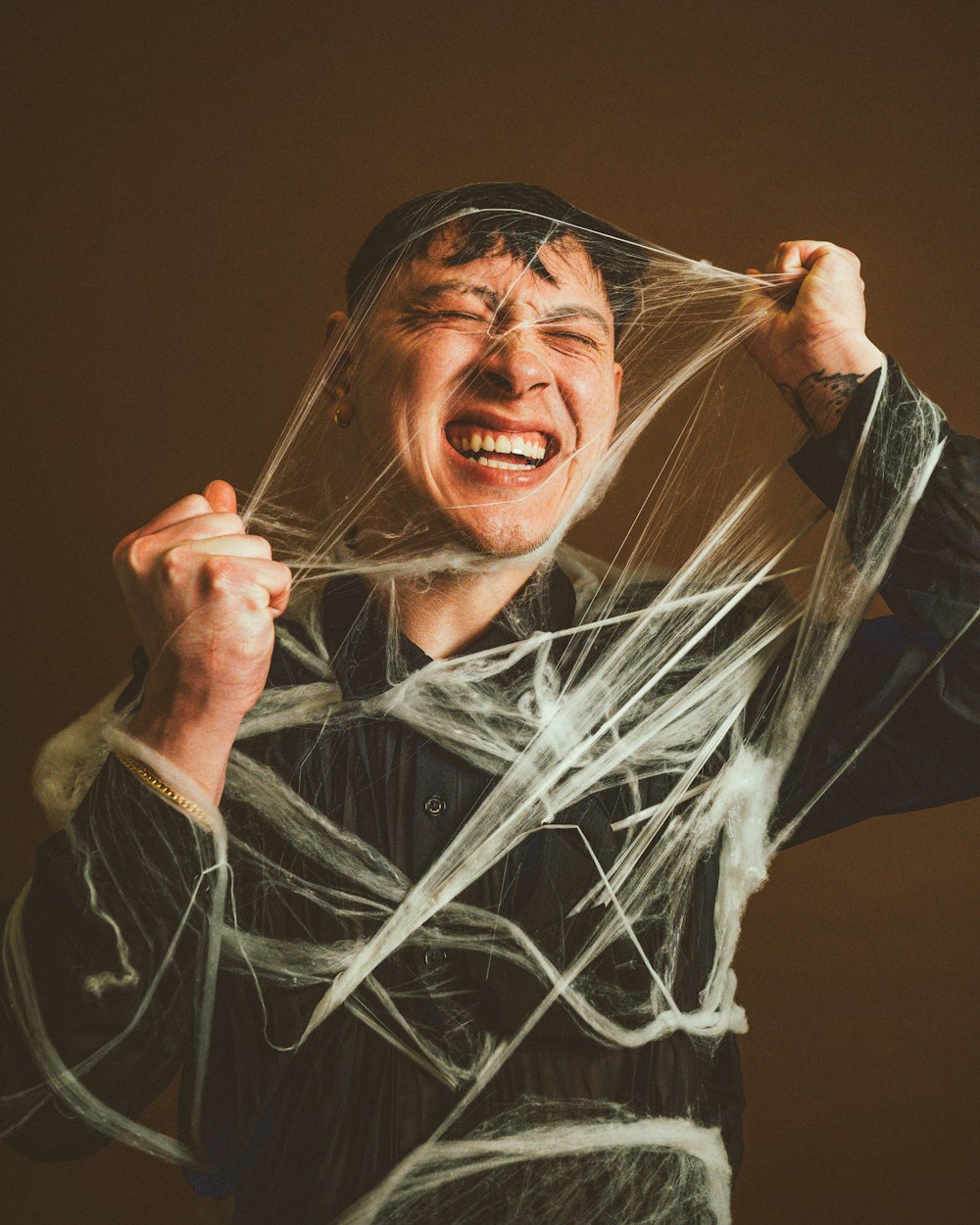 a man holding a string wrapped around his face