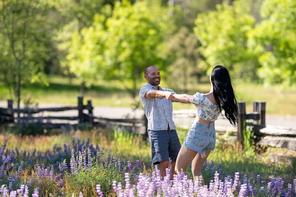 a man and a woman dancing in a field of flowers