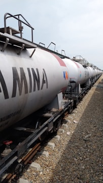 a train with a tanker car on the tracks