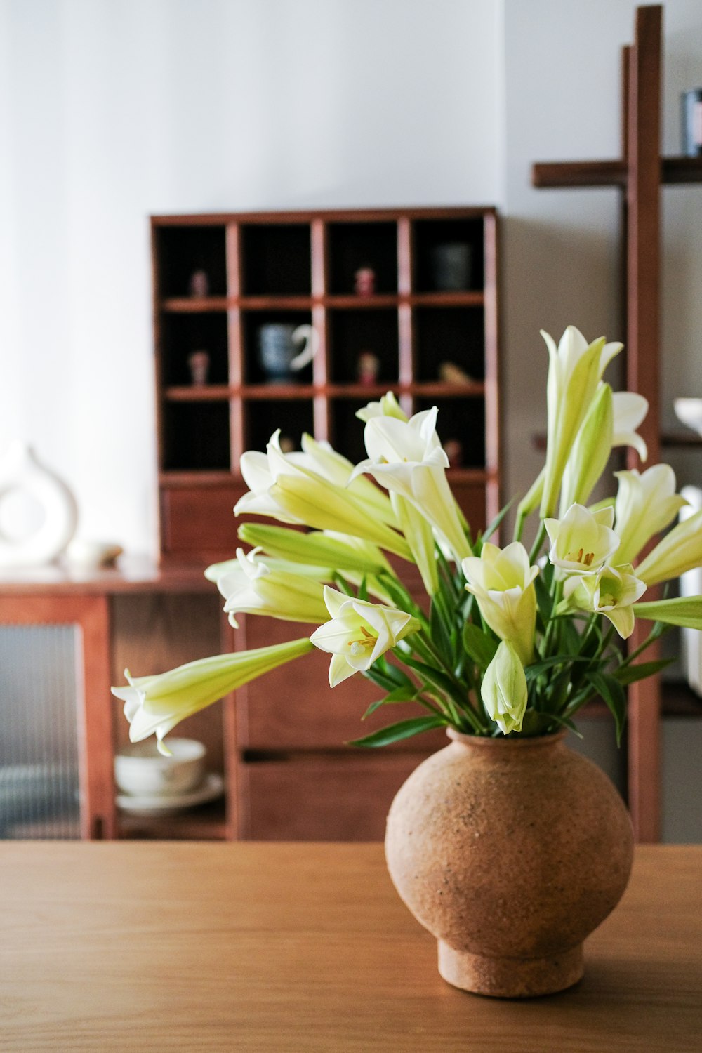 a vase filled with white flowers on top of a wooden table
