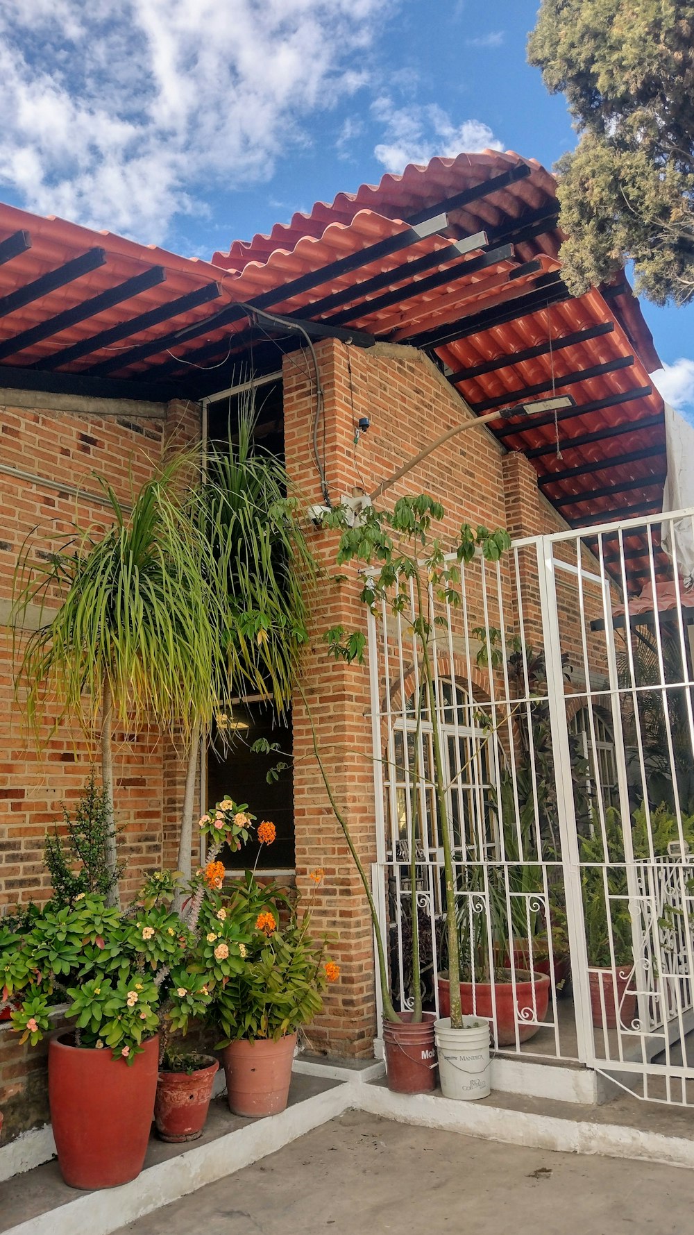 a brick building with potted plants and a gate