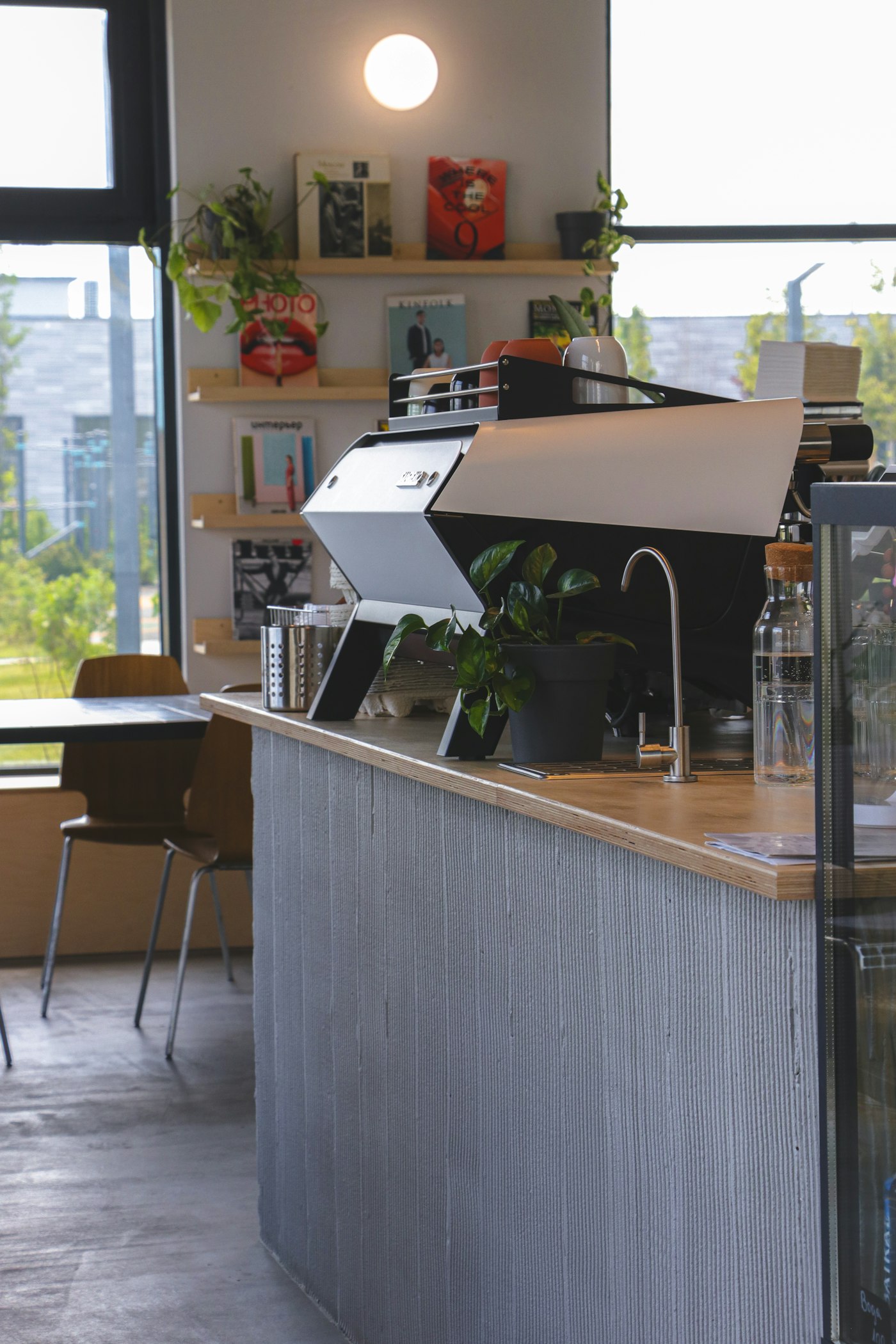 A laptop open on a coffee shop counter at night, showing a dashboard on screen