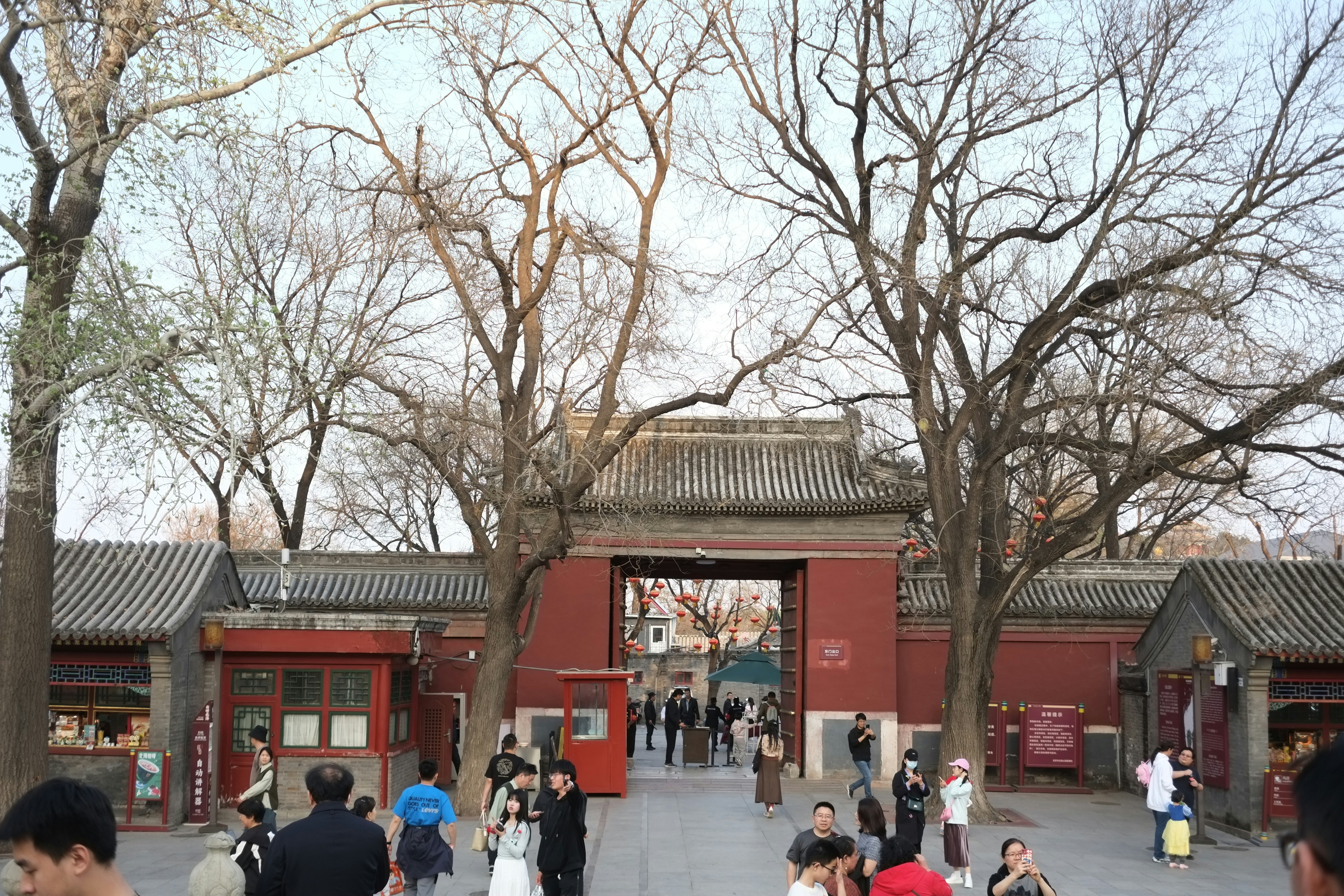 a group of people standing around a red building