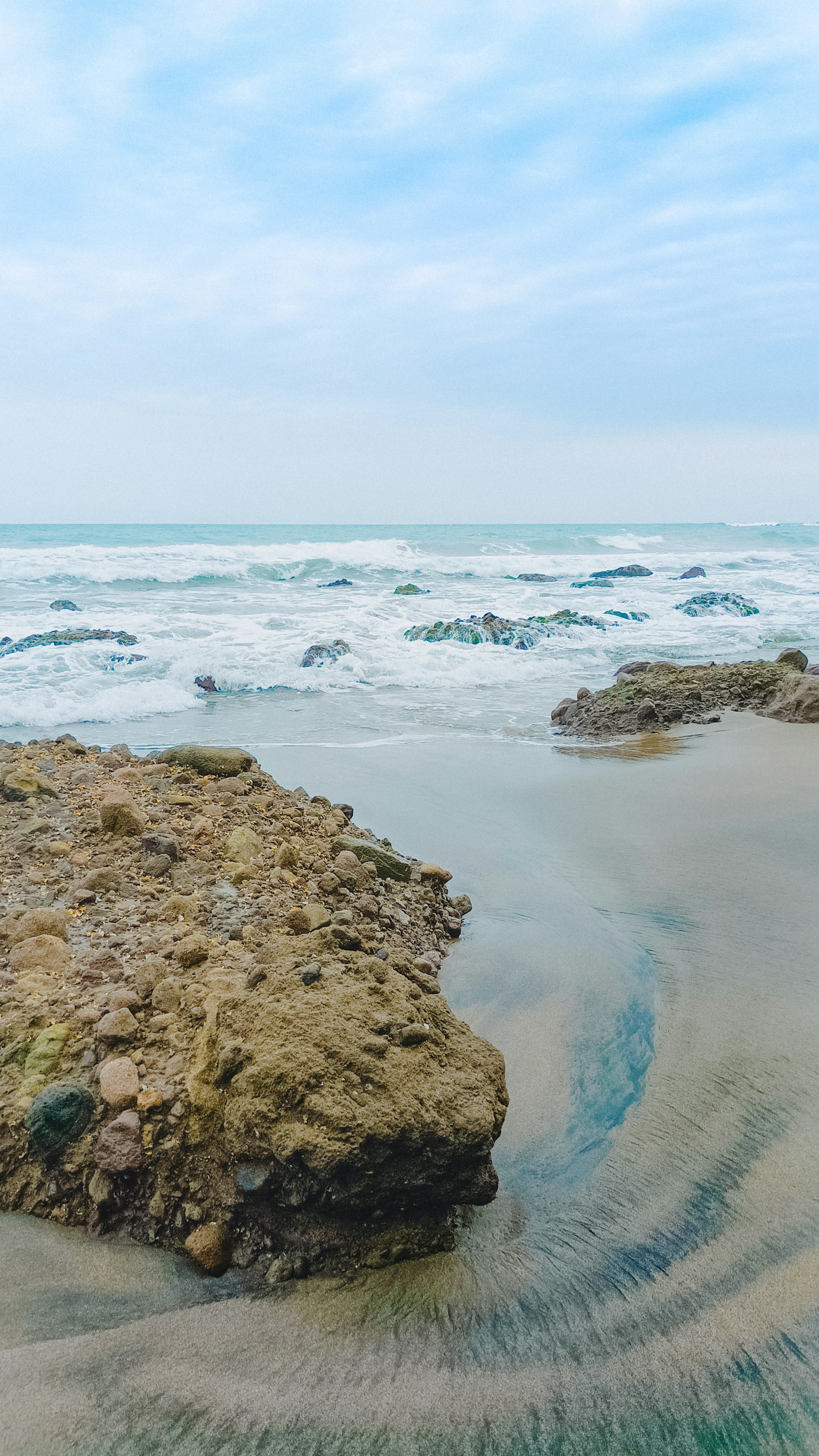 a large rock sitting on top of a sandy beach