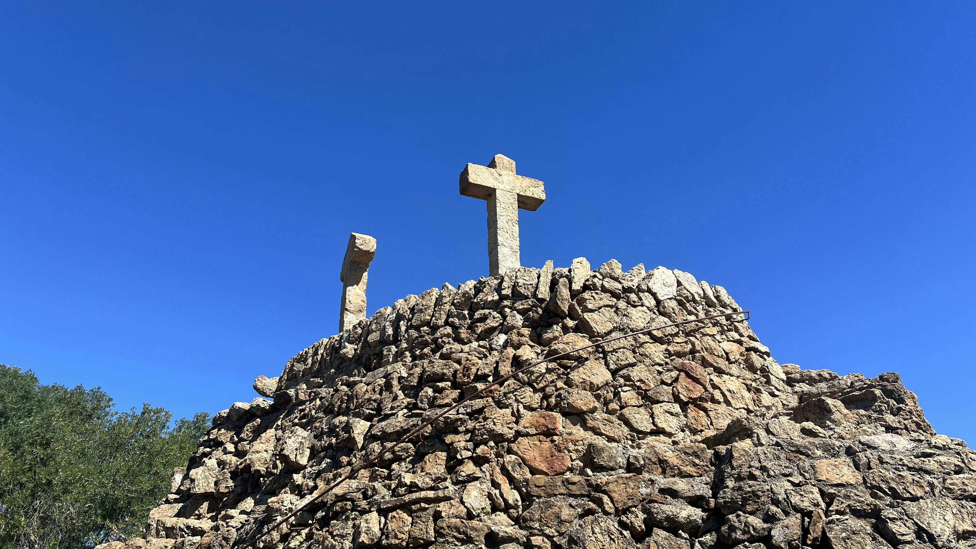 two crosses on top of a rocky hill
