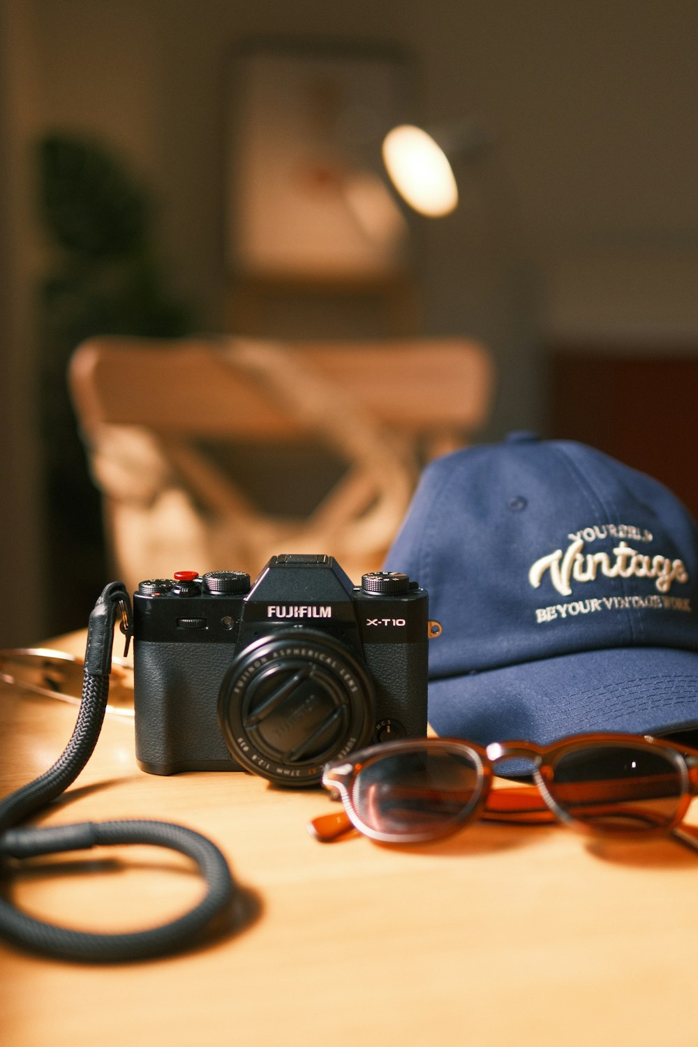 a hat, sunglasses, and a camera sitting on a table