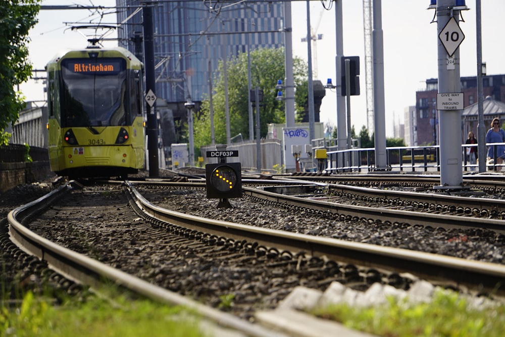 高層ビルの横の線路を走る黄色い列車
