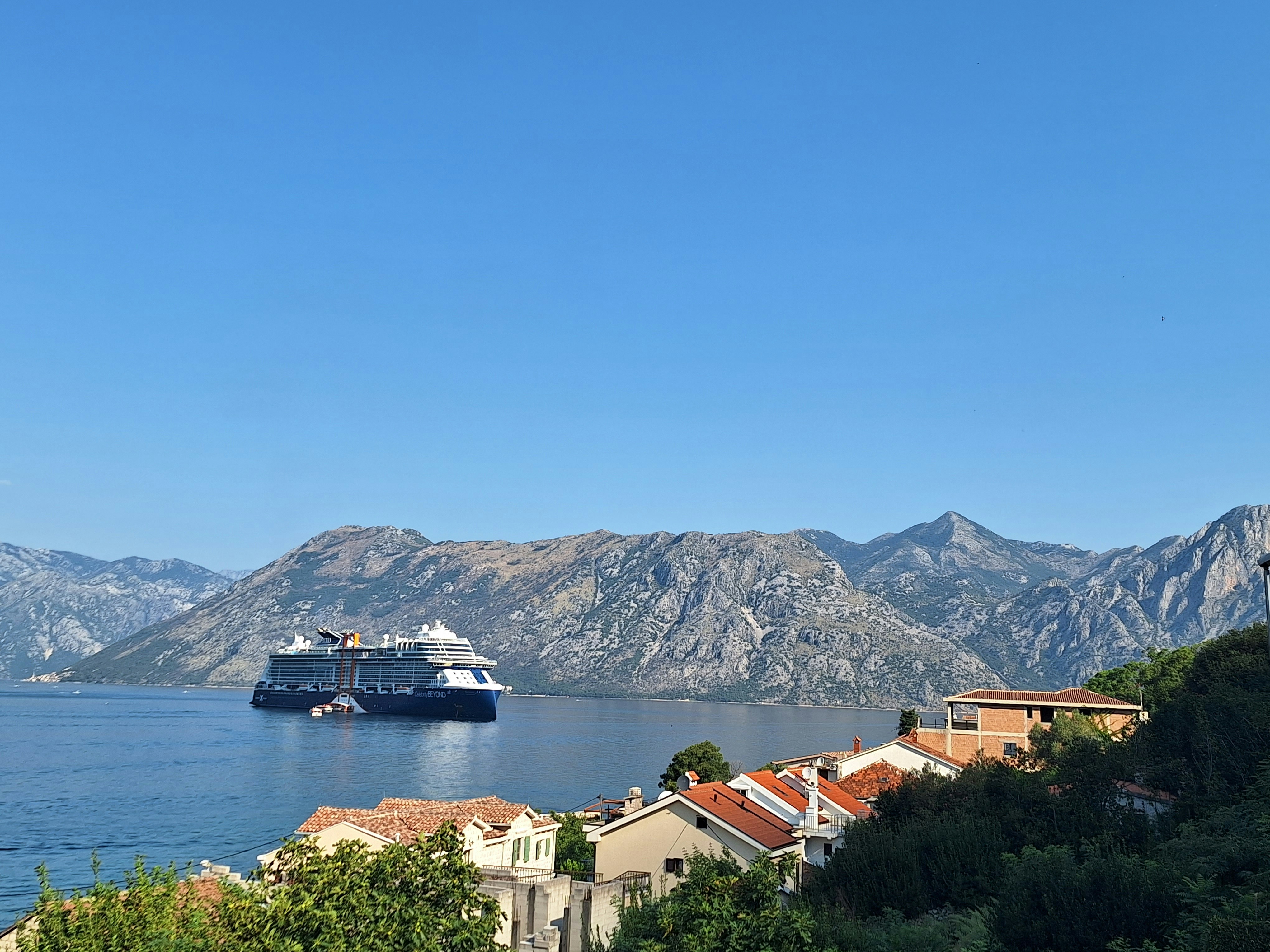 a cruise ship in the water near a mountain range