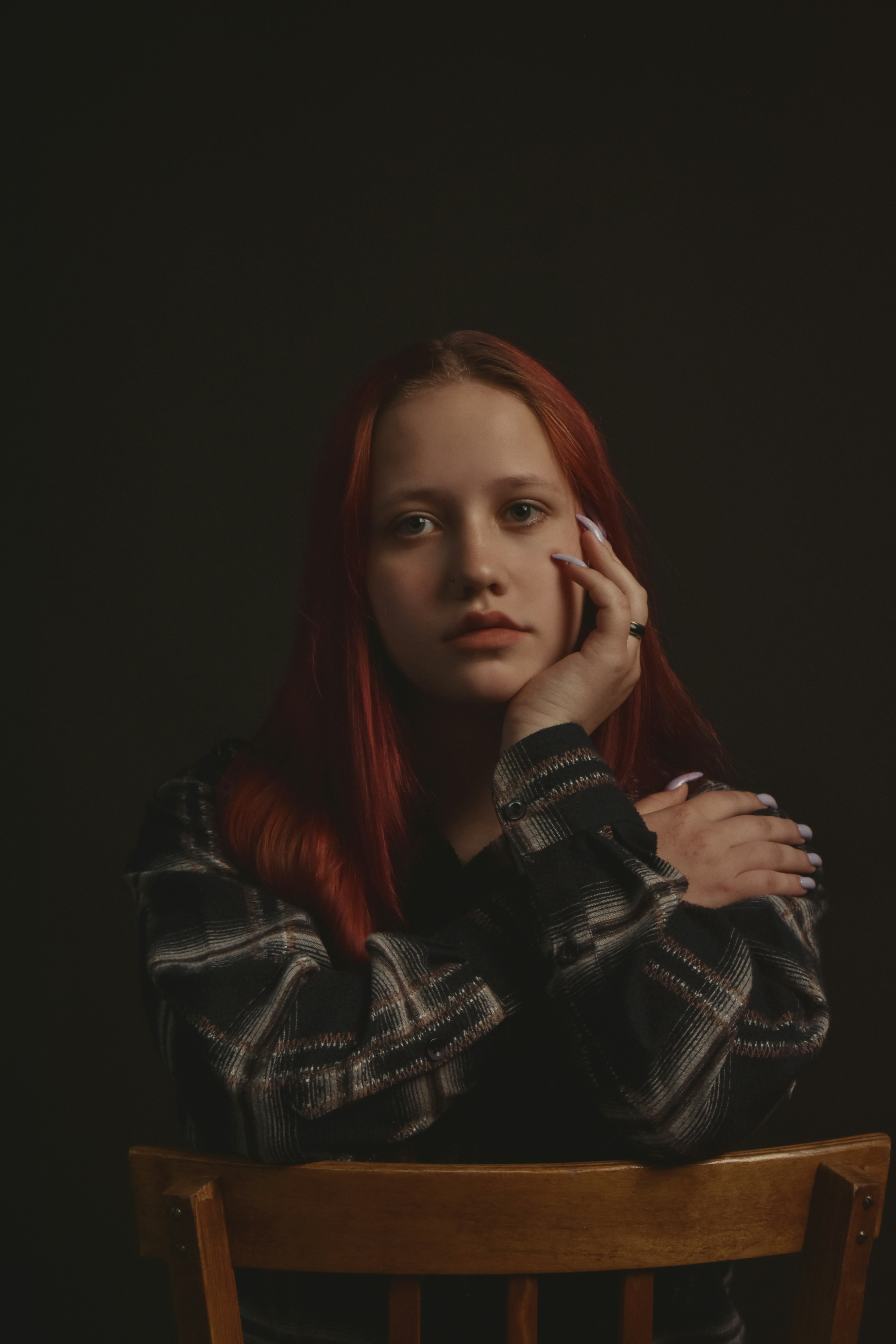 A woman with red hair sitting in a chair photo – Free Woman Image on ...