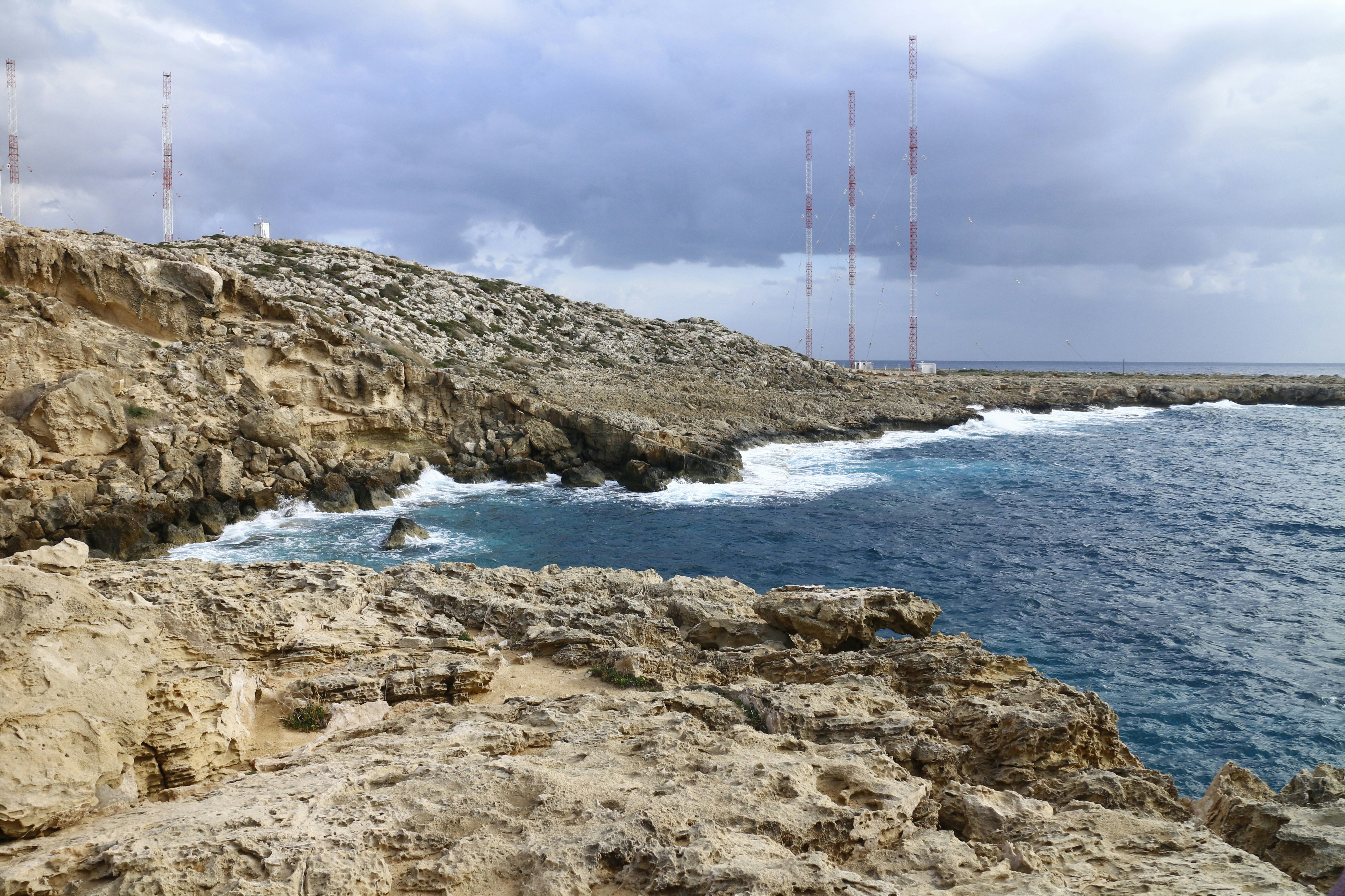 a rocky cliff with a body of water in the foreground