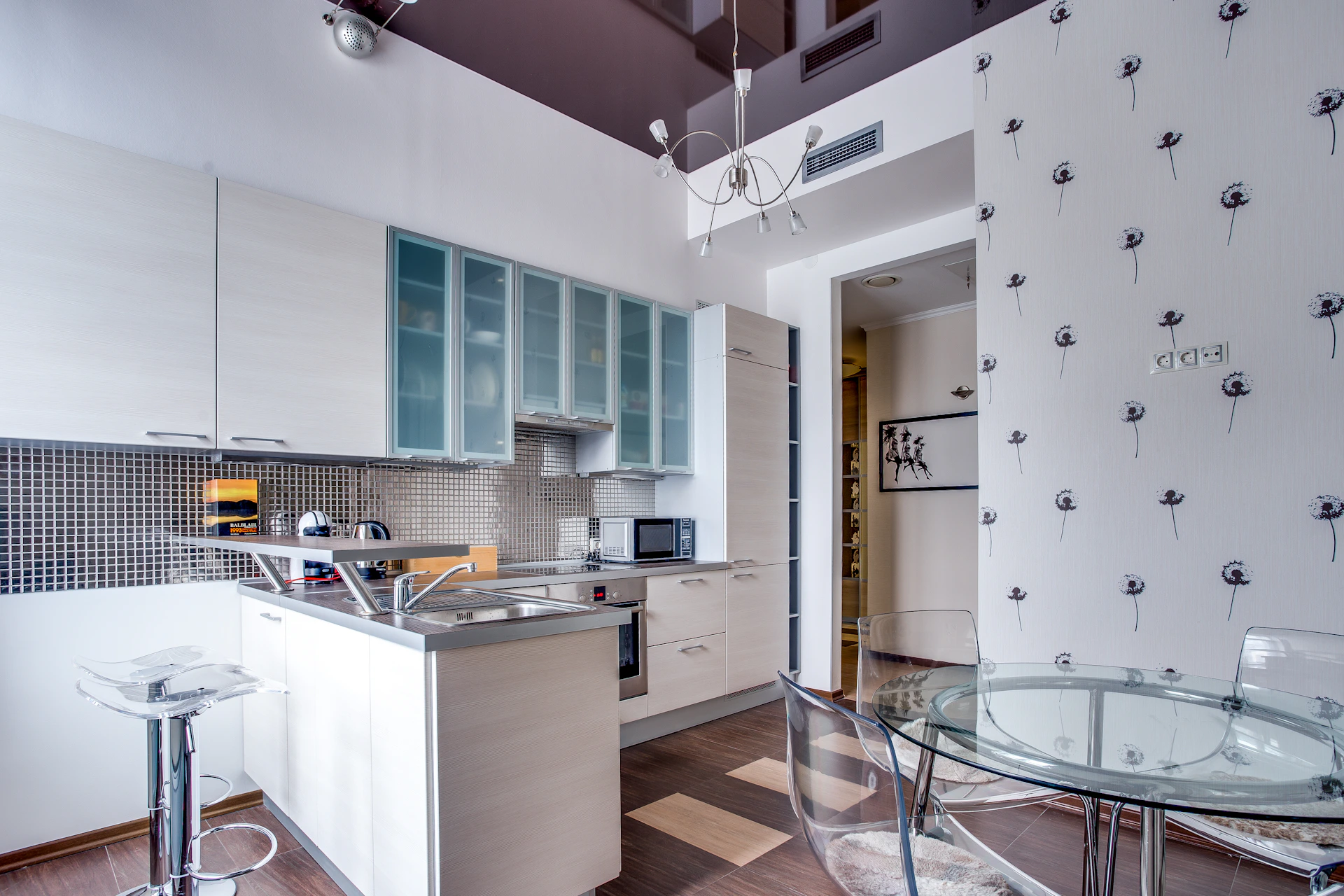 a modern kitchen with a glass table and bar stools
