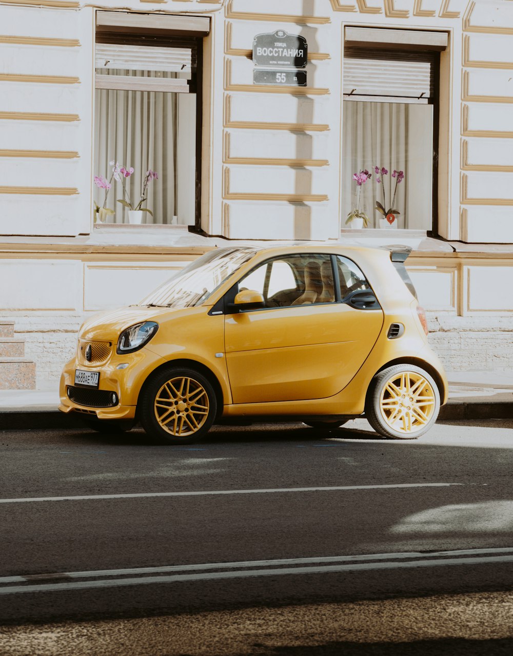 ein kleines gelbes Auto, das am Straßenrand geparkt ist