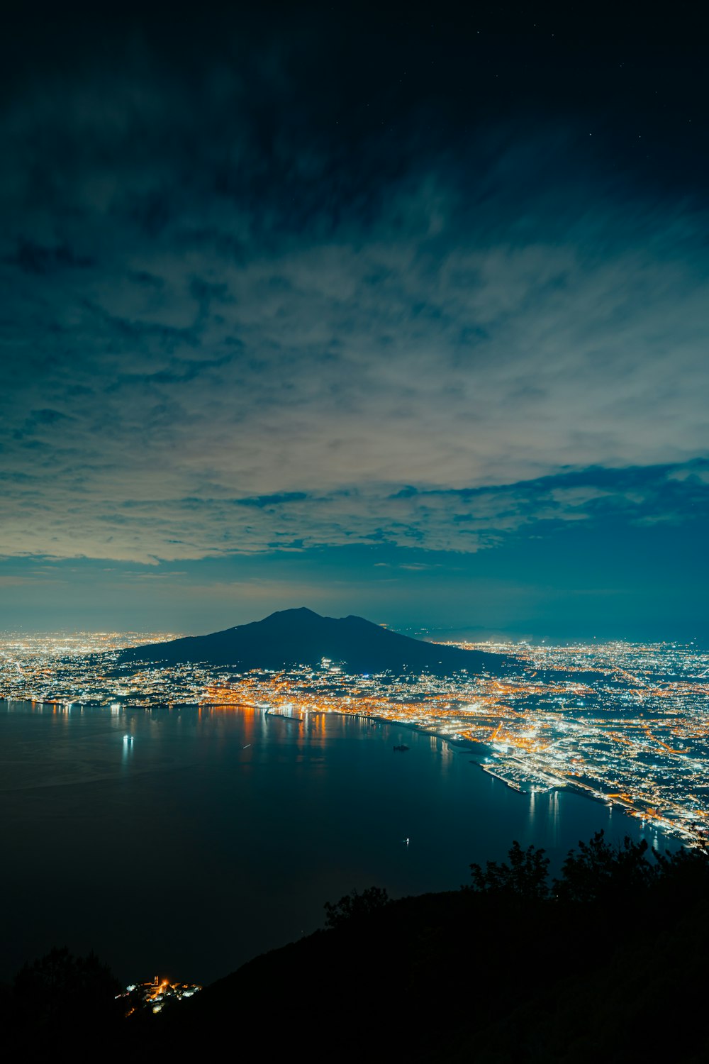 a night view of a city with a mountain in the background