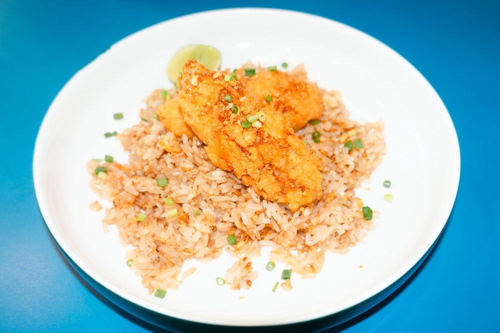 a white plate topped with rice and chicken