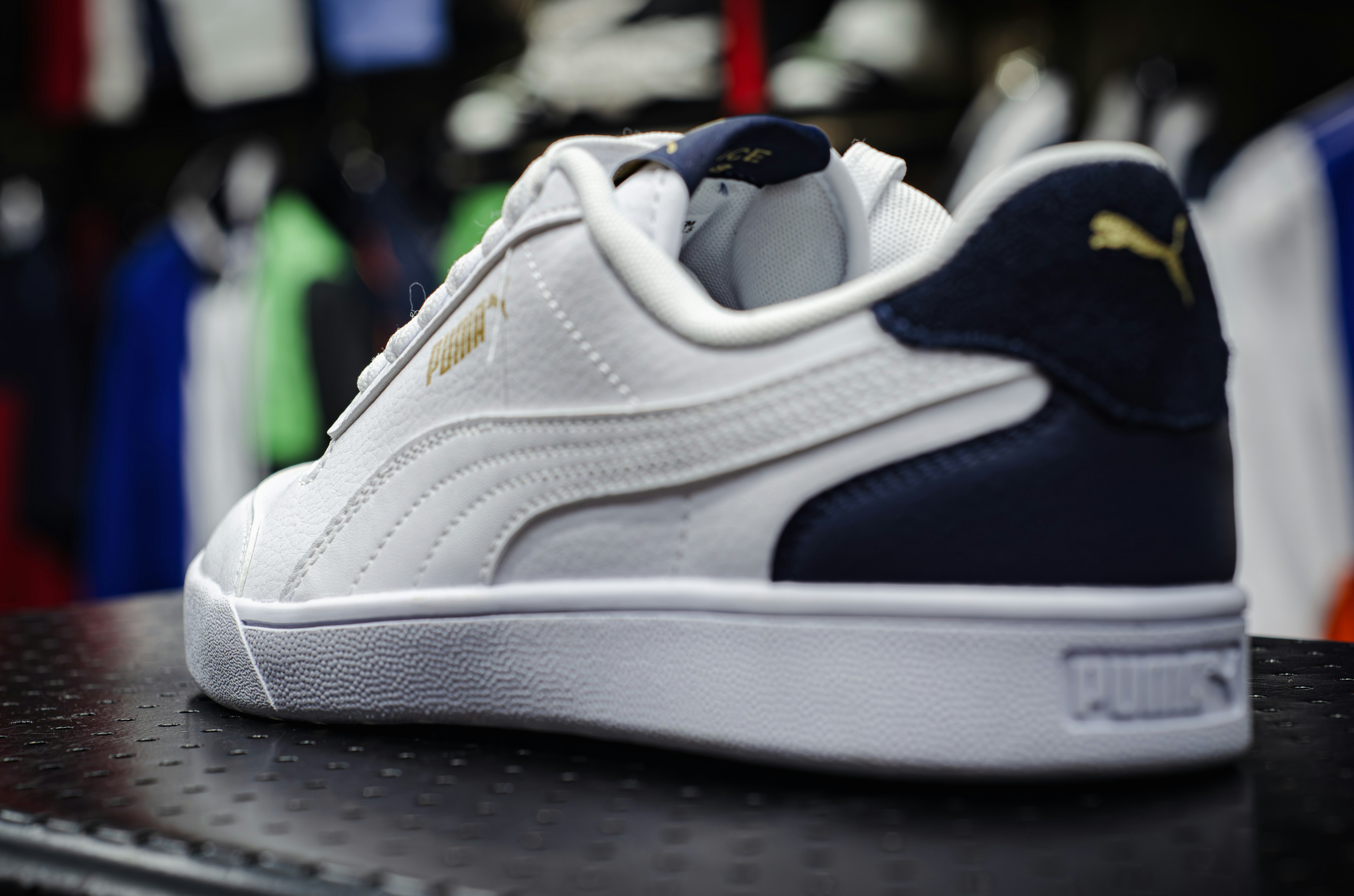 Une basket Puma blanche et bleue sur une étagère