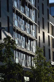 a tall building with lots of windows next to trees