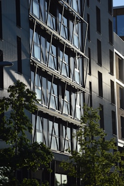 a tall building with lots of windows next to trees