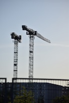 a couple of cranes that are next to a building